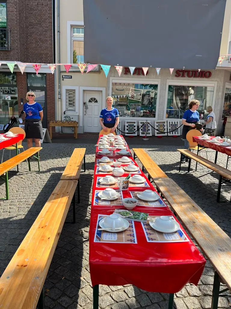 Blick entlang einer vollständig eingedeckten roten Teetafel.