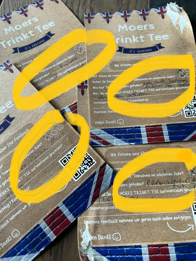 Farbige Einlassarmbänder liegen als Kreise auf einer Veranstaltungsunterlage.